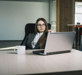 thoughtful-business-woman-with-laptop-table